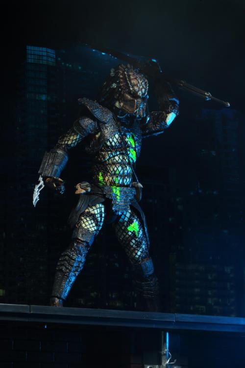 Figura NECA City Hunter Predator Battle Damaged con heridas de sangre verde neón y armadura detallada frente a ciudad nocturna.